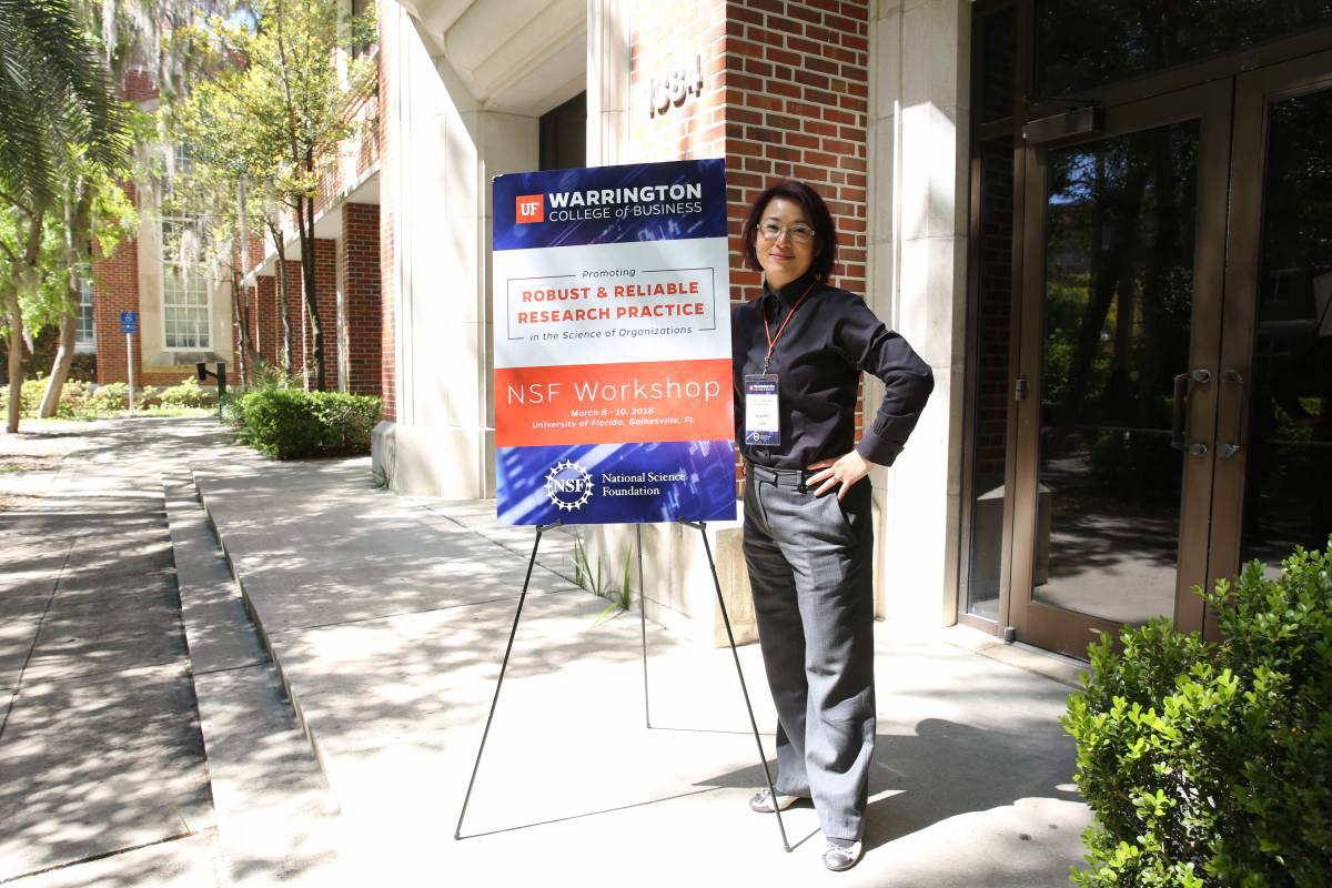 Gwen Lee with the Robust and Reliable Research Practice Seminar sign