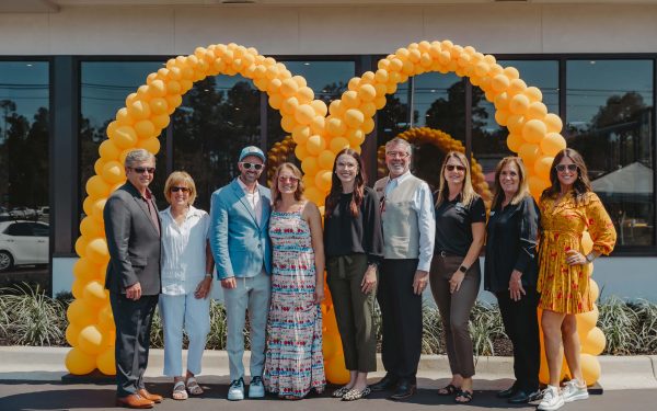 The Costa Family stands in front of a McDonald's M balloon arch during a store opening.