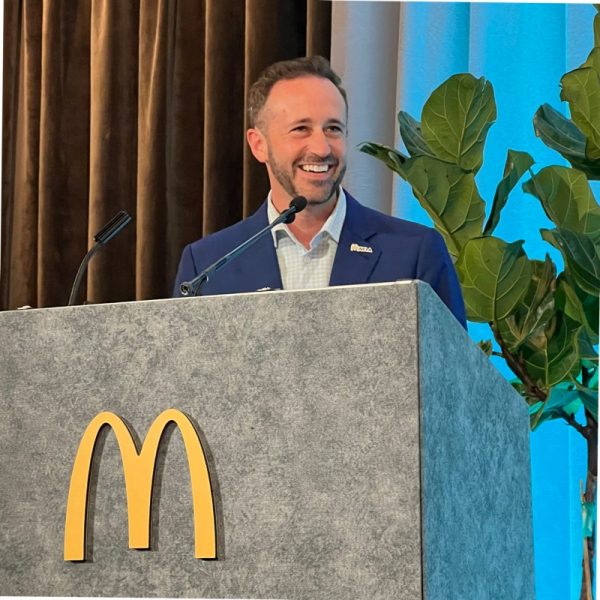 David Costa stands at a podium with a large McDonald's M on the front.
