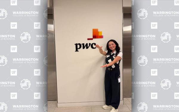 Minuet Greenberg doing the gator chomp in front of PwC sign