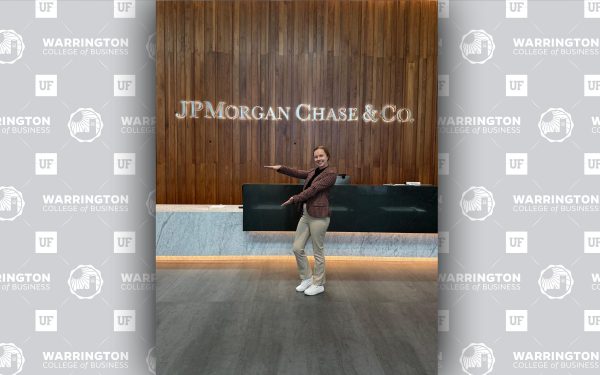 Emily Storr doing the Gator Chomp in front of a JPMorganChase sign