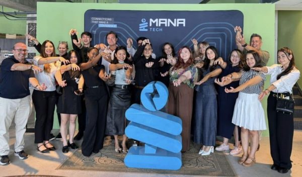 Students do the Gator Chomp in front of the Manatec logo.