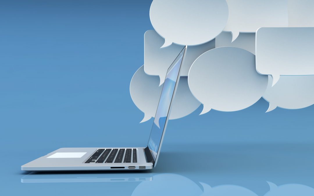 Communication technology, social networking, internet and online messaging concept, white empty speech bubbles and modern laptop computer on blue background with reflection
